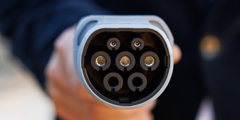 A person is holding a charging cable in their hand
