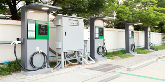 A white electric car is being charged at a charging station